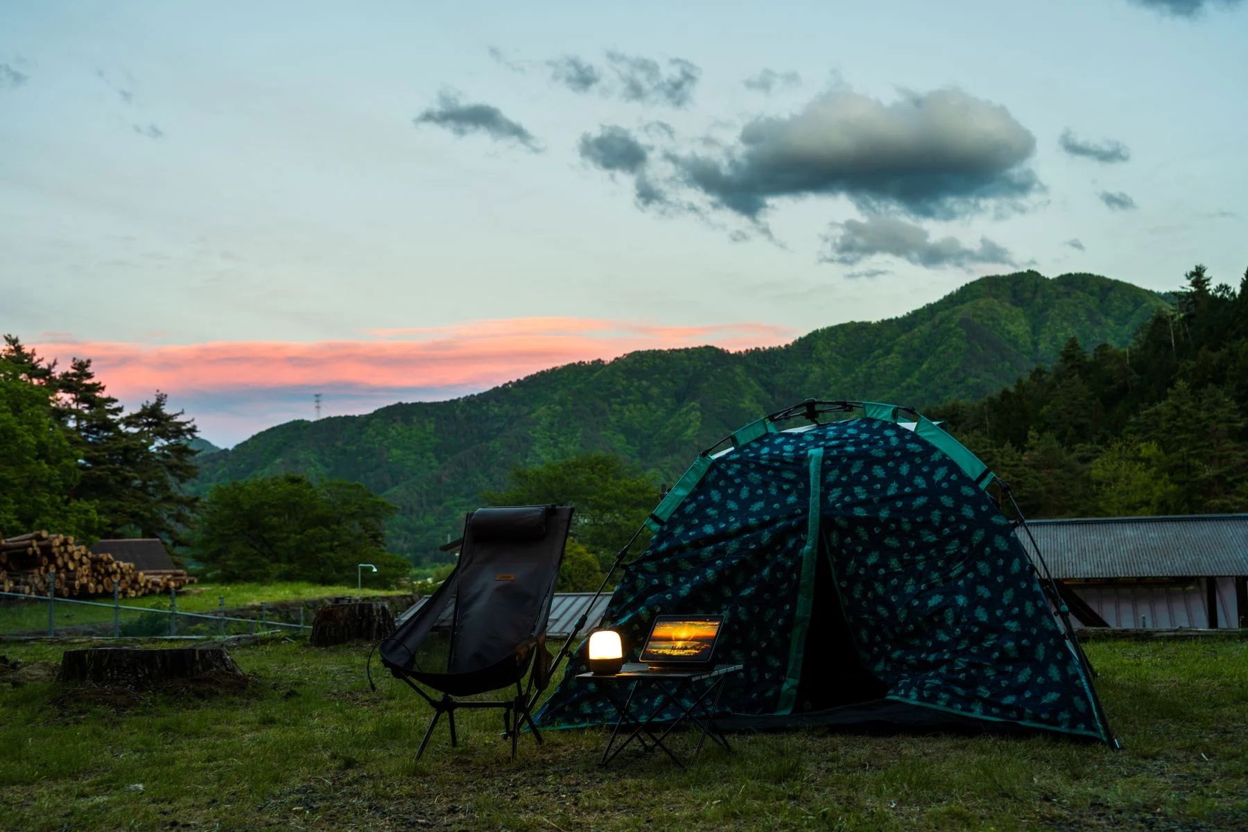 A tent and seating area at an outdoor campsite