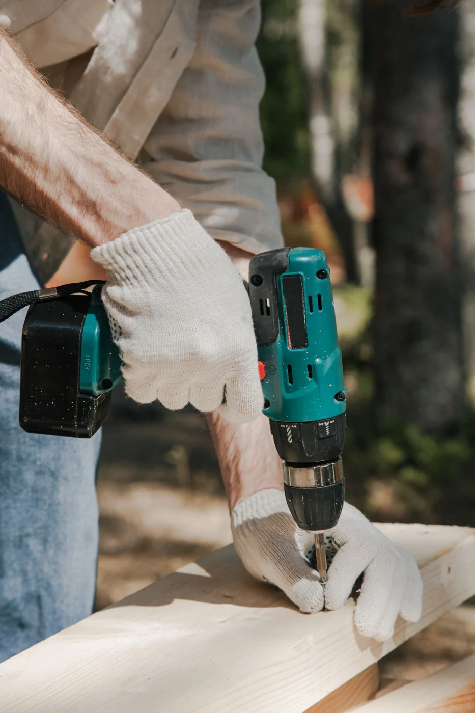A worker drilling into a wooden structure